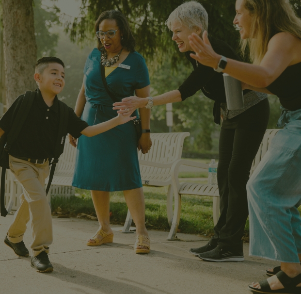 child being greeted by a line of adults