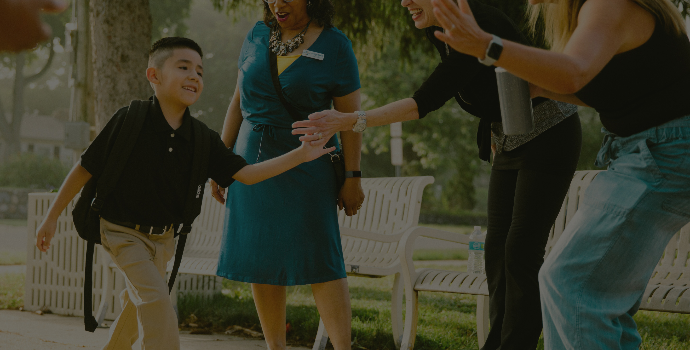 child being greeted by a line of adults