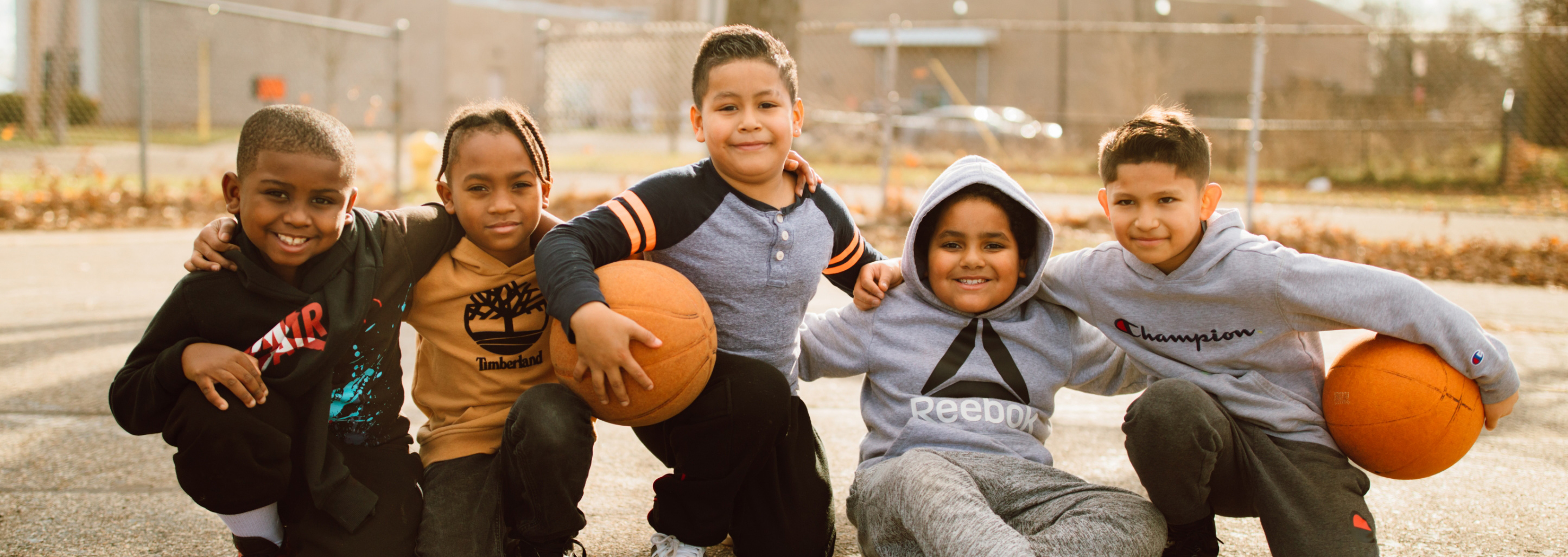 young boys holding basketballs on a basketball court